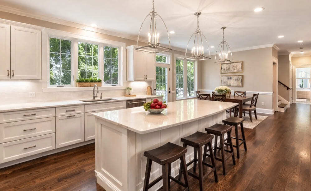 Bright open-concept kitchen with white cabinets, large island, and wood floors in Greater Boston home-3