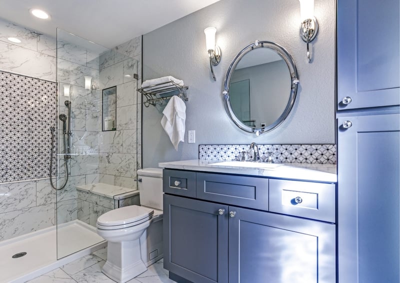 Elegant Boston-area adu bathroom with gray cabinets, glass shower, and patterned tile accents