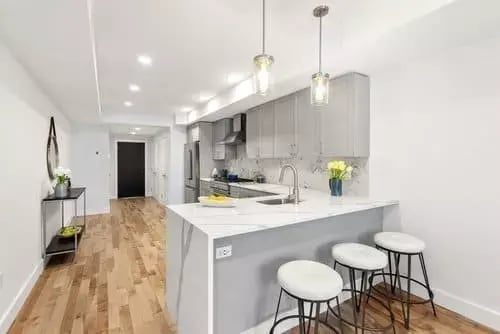 L-shaped island with seating in Boston kitchen remodel by Honorato Company