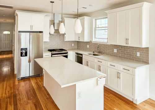 all white kitchen with pendant lights and subway tile