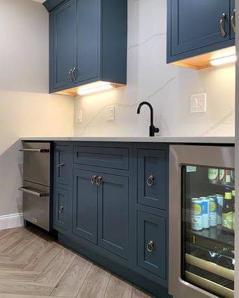 Navy blue cabinet wet bar with beverage fridge and modern finishes in Boston, MA
