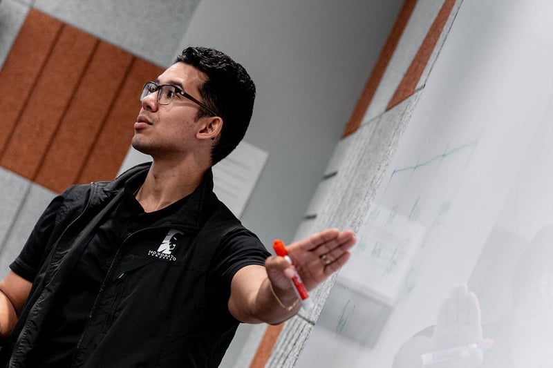 Windson Honorato reviewing design on whiteboard in Boston office