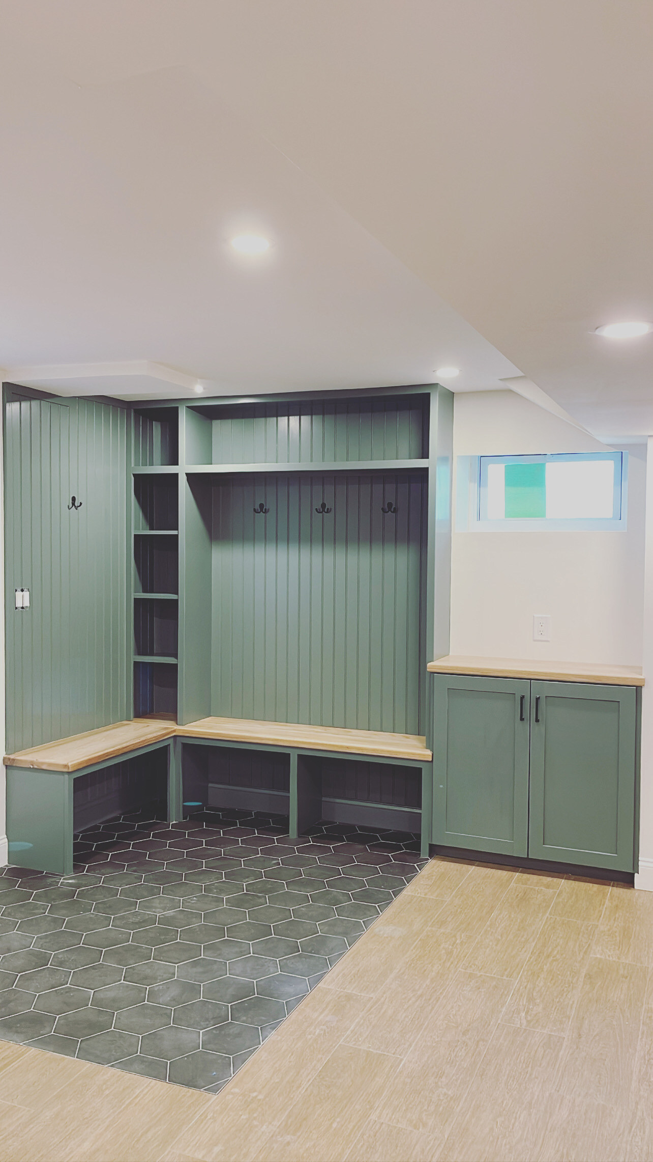 Mudroom remodel in Boston, MA by Honorato Company with built-in seating and shelving