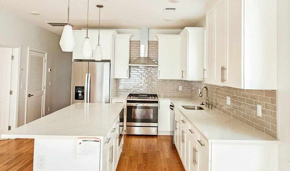 Boston kitchen remodel with pendant lighting above island by Honorato Company