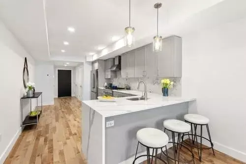 L-shaped island with seating in Boston kitchen remodel by Honorato Company